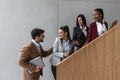 Group of young successful business people on stairs of office building happy with new ideas and satisfied with work support each