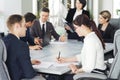 Group of young successful businessmen lawyers communicating together in a conference room while working on a project