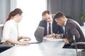 Group of young successful businessmen lawyers communicating together in a conference room while working on a project