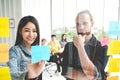 Group of young successful creative multiethnic team smile and brainstorm on project together in modern office. Woman sticking Royalty Free Stock Photo