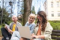 Group of young successful generation z hipster people sitting in park working on laptop computer researching business plan and Royalty Free Stock Photo
