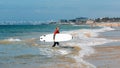 Group of young surfers at Carcavelos beach near Lisbon, Portugal during a summer day