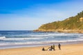 Group of young surfers sitting on the Zurriola beach of San Sebastian