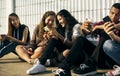 Group of young teenager friends chilling out together using smartphone social media concept