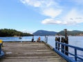 A group of young teenagers fishing and crabbing off the end of a pier in Miners Bay, Gulf Islands, British Columbia, Canada