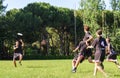 Group of young teenagers people in team wear playing a frisbee game in park oudoors. man tosses a frisbee to a teammate in an