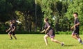 Group of young teenagers people in team wear playing a frisbee game in park oudoors. man tosses a frisbee to a teammate in an