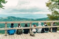 Group of young tourists sitting on a wooden bridge Royalty Free Stock Photo