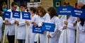 Group of young white coated people holding blue placards with names of Brittish Cattle breeds at Bath & West Show near Bath, Avon,