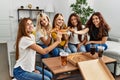 Group of young woman friends smiling happy eating pizza at home Royalty Free Stock Photo