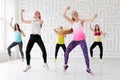 Group of young women dancing with arms raised while having a fitness dance class Royalty Free Stock Photo
