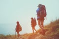 Group young women of hikers walking with backpack on a mountain at sunset.