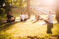 Group of young women practice yoga in park on summer sunny morning Royalty Free Stock Photo