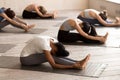 Group of young women practicing yoga, paschimottanasana exercise