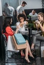 group of young women with shopping bags drinking coffee Royalty Free Stock Photo