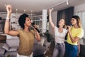 Women spend free time in karaoke sing and have fun together with friends at home