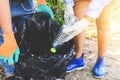 Group of young women volunteers helping to keep nature clean and picking up the garbage plastic bottle from park - Recycling and