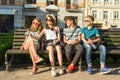 Group of youth is having fun together outdoors in urban background. Summer holidays, education, teenage concept. Royalty Free Stock Photo