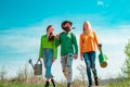 Group of youth work in spring yard with garden tools. People walking in spring garden. Group of gardeners ready for work