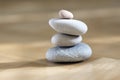 Group of zen stones pile, grey meditation pebbles tower on light brown wooden background in sunlight