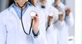 Group of doctors holding stethoscope head close-up. Physicians ready to examine and help patient. Medical help