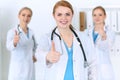 Groupe of medicine doctors show OK sign with thumb up. Success and high level service in health care, best treatment and