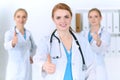 Groupe of medicine doctors show OK sign with thumb up. Success and high level service in health care, best treatment and