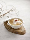 Grouper Fillet in Winter Melon and Conpoy Soup Served in a bowl isolated on wooden board side view on grey background