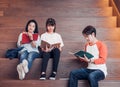 Groups of asian teenage students reading book together at university stair library Royalty Free Stock Photo