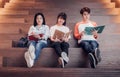 Groups of asian teenage students reading book together at university stair library Royalty Free Stock Photo