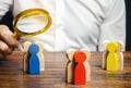 Groups of multicolored wooden people and businessman. The concept of market segmentation. Target audience, customer care. Market Royalty Free Stock Photo