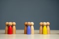 Groups of multicolored wooden people on a gray background. The concept of market segmentation. Target audience, customer care.