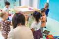 groups of preschoolers painting on the cellophane with their teacher in the nursery Royalty Free Stock Photo