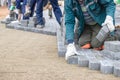 Construction workers laying bricks for pavement in a new outdoor area on a clear day Royalty Free Stock Photo