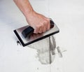 Grouting tiles with rubber trowel man hand Royalty Free Stock Photo