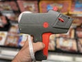 Retail store hand holding manual pricing gun side view