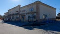 Retail strip mall clear blue sky corner view tree and picnic tables