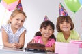 They grow up so fast...Portrait of three smiling friends at a birthday party. Royalty Free Stock Photo