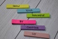 Grow Your Business by Choosing Us text on sticky notes isolated on office desk