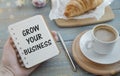 Grow your business words on office table with computer, coffee, notepad, smartphone Royalty Free Stock Photo