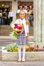 Grower Baby girl first-grader with bouquet of flowers at the school