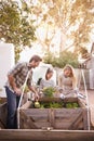 Growing family goodness. a family gardening together in their backyard.