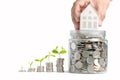 Growing Money - Hand man holding house model on coins in glass jar Royalty Free Stock Photo