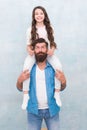 Growing mustache is fun. Little daughter twist fathers moustache. Happy family grey background. Bearded man ride child