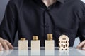 Growing stacks of coins and a model of a house. Property investment and house mortgage financial concept