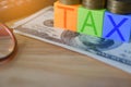 Growing taxes - Closeup of colour blocks with TAX and money on t