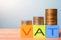 Growing taxes - colour blocks with VAT and money stacks