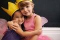 Growing up with big imaginations. Portrait of two little girls embracing while dressed up as fairies. Royalty Free Stock Photo