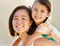 Growing up to be just like mommy. Cropped portrait of an attractive young woman piggybacking her daughter on the beach. Royalty Free Stock Photo