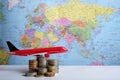 Grown up coins and aeroplane on world map background,world business concept